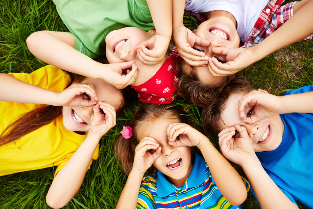 Group of cute children lying on grass 