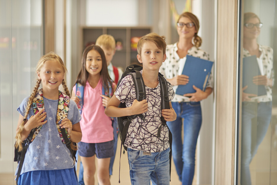 Pupils and teacher walking across the corridor